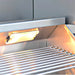 Metallic grill with glowing heating element inside a kitchen hood